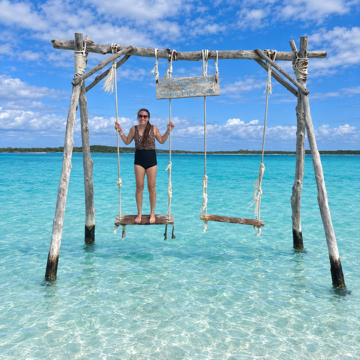 Katrina DeGrande on a swing above the turquoise water at Little Pipe Cay in the Exumas, Bahamas.