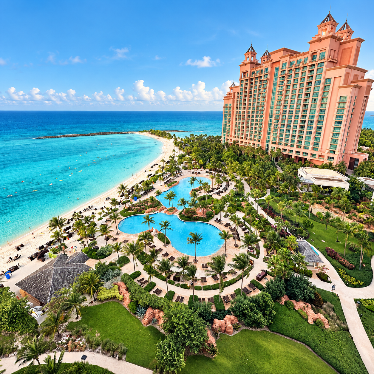 View from a balcony at The Reef at Atlantis Paradise Island, overlooking Cascades Pool, The Cove, and the turquoise water along Paradise Beach.