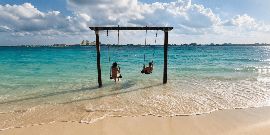 Katrina DeGrande of Bahama Mama Travel Co. on ocean swings at Sandals Royal Bahamian's private island in Nassau, Bahamas.