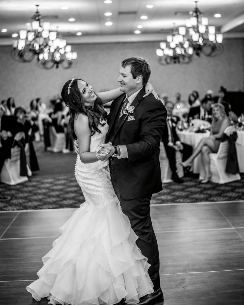 Black-and-white photo of Katrina DeGrande, founder of Bahama Mama Travel Co., dancing with her husband Sean at their wedding.